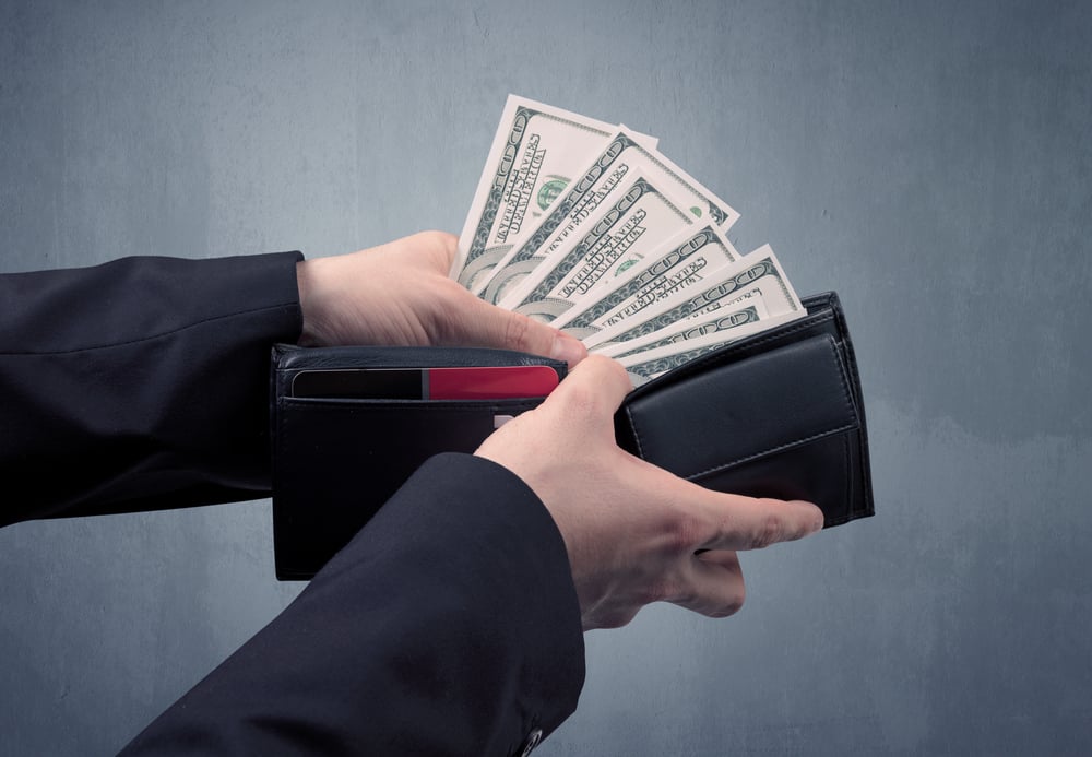 Businessmans hand in suit takes out dollar money from a wallet-1