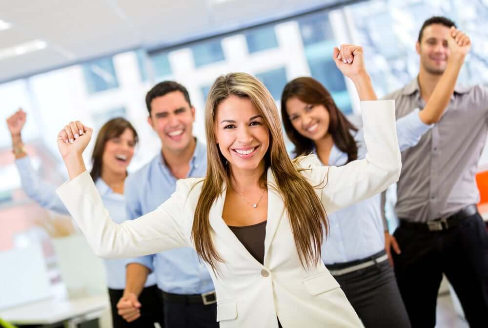 Successful business team with arms up at the office-2